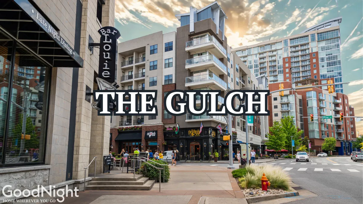 A lively streetscape in The Gulch showing Bar Louie and modern residential buildings, with people dining at outdoor cafes, shopping, and socializing. The energetic atmosphere and contemporary vibe reflect the area’s appeal for after-work relaxation and dining.