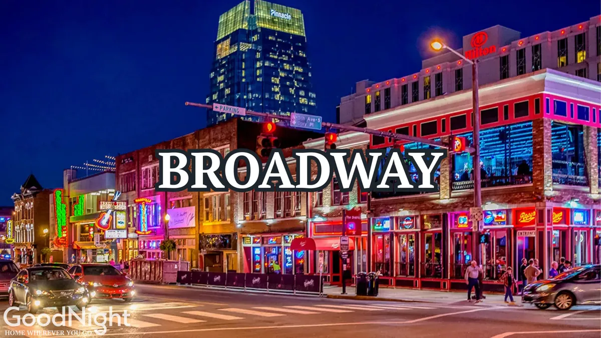 A vibrant nighttime street scene on Broadway, with neon signs illuminating busy sidewalks. People mill about, restaurants and live music venues line the street, and the energy of Nashville’s nightlife is palpable.